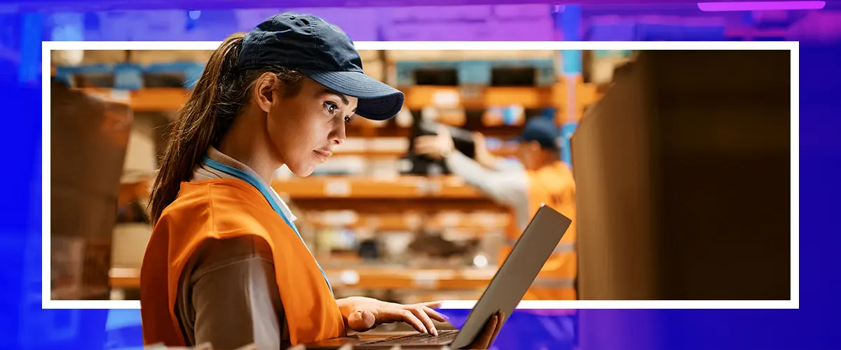 Woman in a warehouse using a laptop